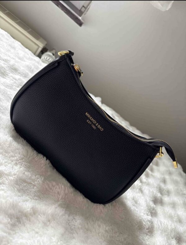 Handtasche schwarz getragen mit Gold akzent